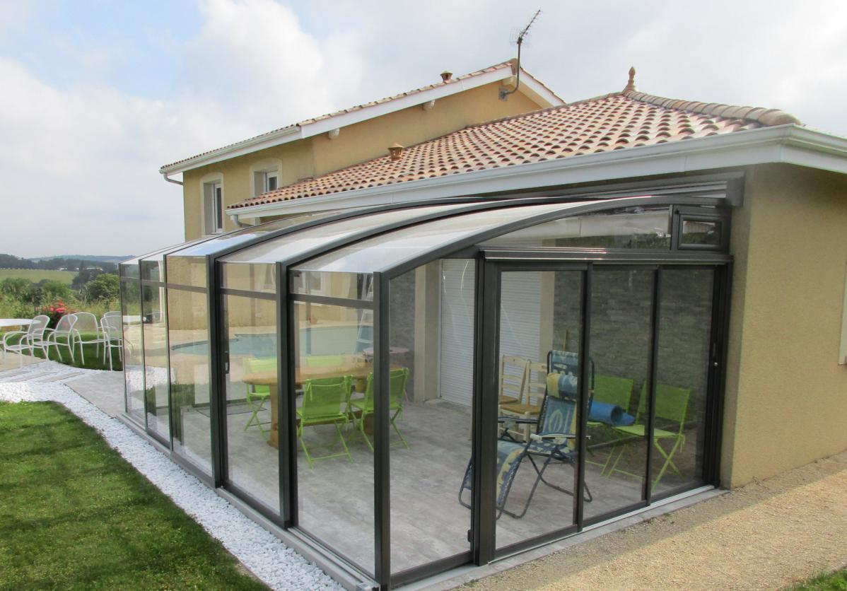 Abri de terrasse de type véranda rétractable avec store motorisé intégré
